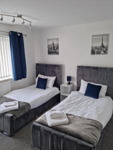 埃尔斯米尔港Entire House - Cheshire Oaks/Ellesmere Port的一间卧室配有两张床和一张奥斯曼 ⁇ 鱼。