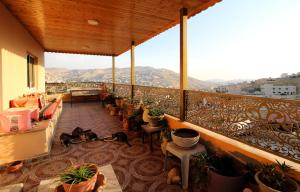 瓦迪穆萨Petra Bed & Breakfast的阳台配有桌椅和盆栽植物
