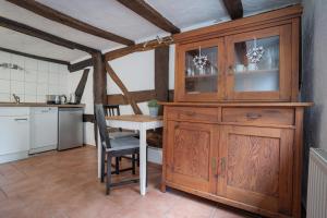 锡根Wohnen in malerischer Altstadt的厨房配有桌子和木制橱柜。