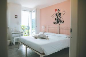 Brovello-CarpugninoB&B il Cappellaio di Erika的一间卧室配有一张带粉红色墙壁的大床