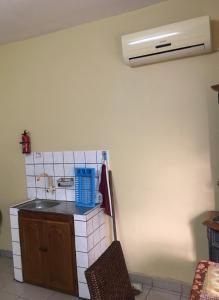 杜阿拉Vicky Appartements Palmengarten Douala Maképè Belavie的厨房配有水槽,墙上装有空调
