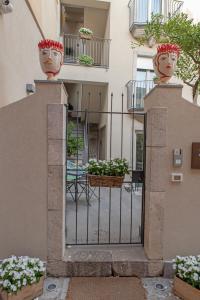 陶尔米纳Villa D'Orville luxury suites Taormina的通往建筑物的大门,上面有两瓶花