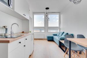 奥普尔Serce Opola Katowicka 39的厨房以及带蓝色沙发的客厅。