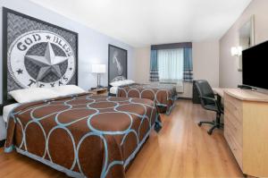 新布朗费尔斯Super 8 by Wyndham New Braunfels I-35的酒店客房设有两张床和一台平面电视。