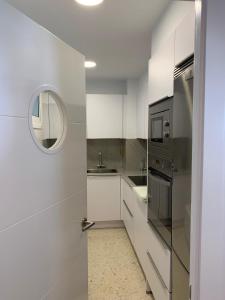 尼格兰Mirando al Mar. Playa America的厨房配有白色橱柜、水槽和镜子