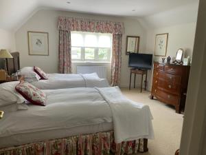 赛伦塞斯特Field End House的一间卧室设有两张床、一个梳妆台和窗户。