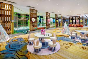 龙岗深圳龙岗珠江皇冠假日酒店的儿童游戏室配有桌椅
