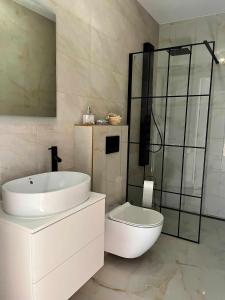 斯蒂格纳Bałtyckie Klimaty的白色的浴室设有水槽和卫生间。
