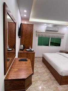 瓦迪穆萨Petra Family Hotel的一间卧室配有一张床和一张木桌