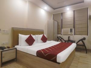 新德里Hotel Grace, Karol Bagh, New Delhi的一间卧室配有一张带红色枕头的大床