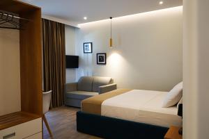 格勒姆DelMar Hotel-Apart的配有一张床和一把椅子的酒店客房