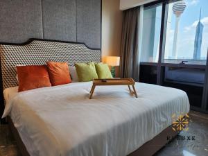 吉隆坡The Platinum 2 KLCC Premium Suite by Reluxe Kuala Lumpur的一间卧室配有一张桌子和一张床铺