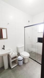 因比图巴Suítes do Vale - Praia do Rosa的浴室配有卫生间、盥洗盆和淋浴。