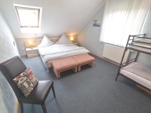 卡佩尔-格拉芬豪森Ferienwohnung Rheintal的一间小卧室,配有一张床和一把椅子