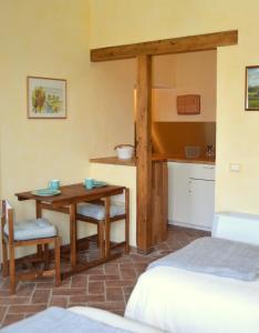 巴斯基里奥Agriturismo Borgo San Francesco的一间设有桌子和床的房间和一间厨房