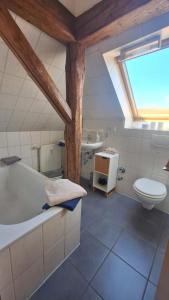Bad RehburgFerienwohnung Tölle的带浴缸、卫生间和盥洗盆的浴室