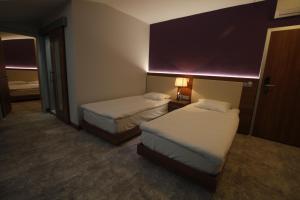 科贾埃利Business Palas Otel的酒店客房,设有两张床和一盏灯