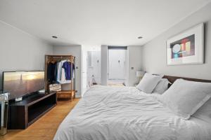 伦敦Captivating 3-Bed House in London Holland Park的一间卧室配有一张大床和一台平面电视