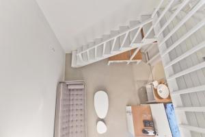 林都斯林多斯舒适套房旅馆的浴室设有白色的架子和白色的楼梯。