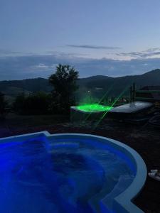 帕利亚尼西亚Villas by Vysche Neba的一座拥有绿色灯光的游泳池