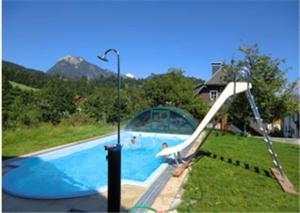巴德米滕多夫邦茨拜恩霍夫农家乐的庭院中带滑梯的游泳池