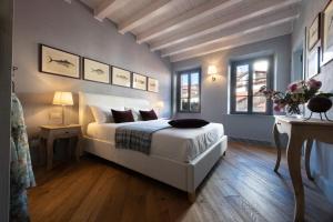 斯特雷萨Isola Bella Apartments - Via del Voltone的一间卧室配有一张床、一张桌子和两个窗户