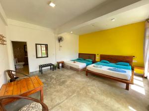埃拉埃拉旅馆的一间卧室设有两张床和黄色的墙壁