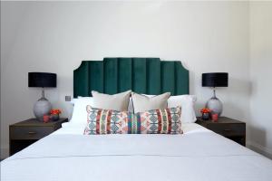 伦敦Luxurious Covent Garden Penthouse的一间卧室配有一张带两盏灯的大型白色床。