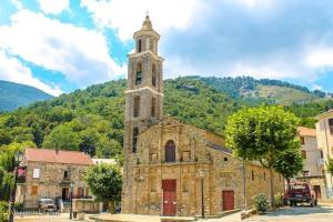 VezzaniMaison de village, charmante et authentique, haute-corse的一座古老的石头教堂,在镇上有一个钟楼