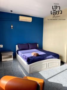 KHAO KIEOW Hotel โรงแรมเขาเขียว的蓝色的卧室,床上挂着一只猫
