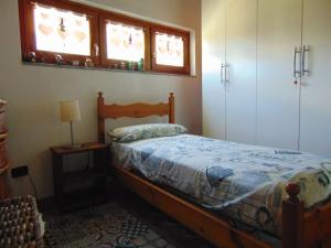 IssogneCasa ad Issogne chez Piero Vda Issogne-002的一间卧室设有木床和2个窗户。