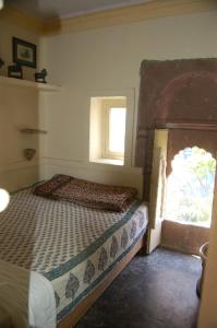 焦特布尔Bristows Haveli Homestay的一间卧室设有一张床和一个窗口