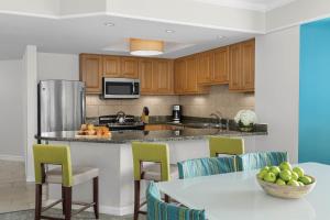 希尔顿黑德岛格兰德海洋万豪酒店的厨房配有木制橱柜和1张带水果碗的桌子