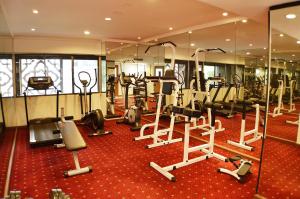 新加坡Hotel Grand Pacific的一间铺有红地毯的健身房,配有跑步机和椭圆机
