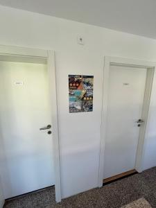 托尔明Azimut Hiša的墙上有照片的房间的两扇门