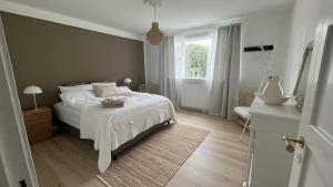 哈纳弗约德尔Heklan的卧室配有白色的床和窗户。