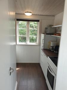 奥基克比St. Strandbygaard的一间小厨房,配有白色家电和窗户