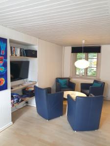 奥基克比St. Strandbygaard的客厅配有蓝色的椅子和桌子