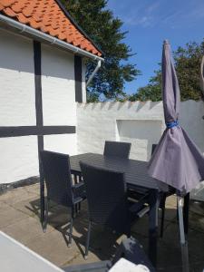 奥基克比St. Strandbygaard的庭院内桌椅和遮阳伞