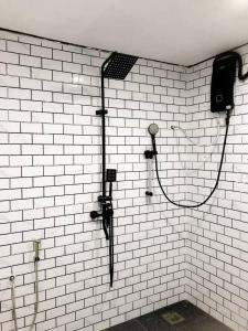 瓜拉勿述Abe cottage的浴室设有白色瓷砖墙壁和淋浴。