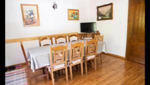 阿列谢尼Casa dintre Brazi的一间带桌椅和电视的用餐室