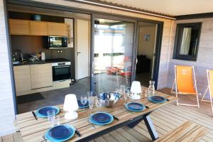 瑞卢维尔莱潘Cottage des Dunes - Chalet de 49m2 climatisé - 6 personnes的厨房里一张带蓝色板的木桌