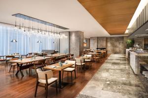 上海上海万信福朋喜来登酒店的一间带木桌椅的餐厅和一间酒吧