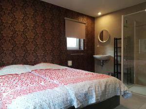 韦姆Maison La Lande的卧室配有红色和白色的床和水槽。