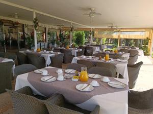 Las CabrasHotel Jardin del Lago的一间设有白色桌椅的餐厅