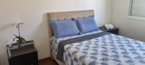 佩洛塔斯Casa no Moradas的一间卧室配有一张带蓝色和白色棉被的床