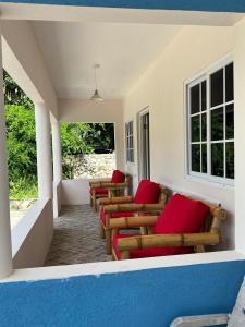 尼格瑞尔Stoney Gate Cottages的门廊上一排带红色枕头的椅子