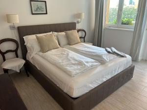 阿尔蒙诺圣巴特鲁姆Agriturismo Al Robale的卧室内的一张带白色床单和枕头的床