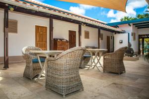 克拉伦代克Bonaire 2 Stay Playa的庭院里摆放着几把椅子和桌子
