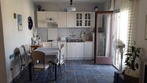 萨利Apartment Nera的厨房配有白色橱柜和桌椅